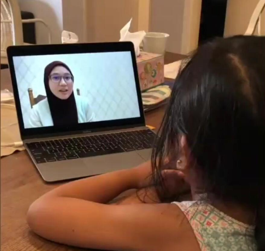 Female student listening to teacher's lecture via laptop and International School in Selangor, Malaysia